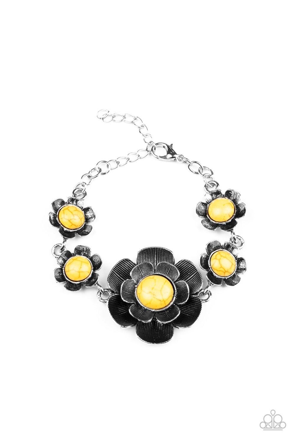 Paparazzi Accessories Badlands Blossom - Yellow Layers of lifelike silver petals bloom from sunny yellow centers, creating gorgeous floral fittings that wrap around the wrist. The frames vary in size, with the largest flower sitting at the center of the d