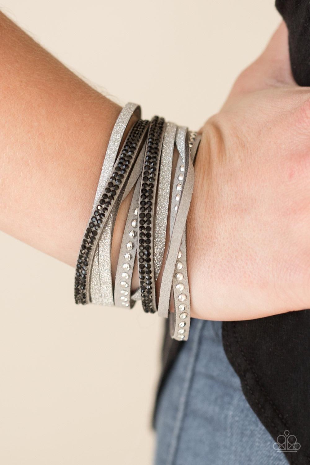 Paparazzi Accessories Once Upon A SHOWTIME - Silver Strands of glistening silver studs, glassy black rhinestones, and gray suede dusted in glitter wrap around the wrist, creating mismatched shimmer. The elongated band allows for a trendy double wrap desig