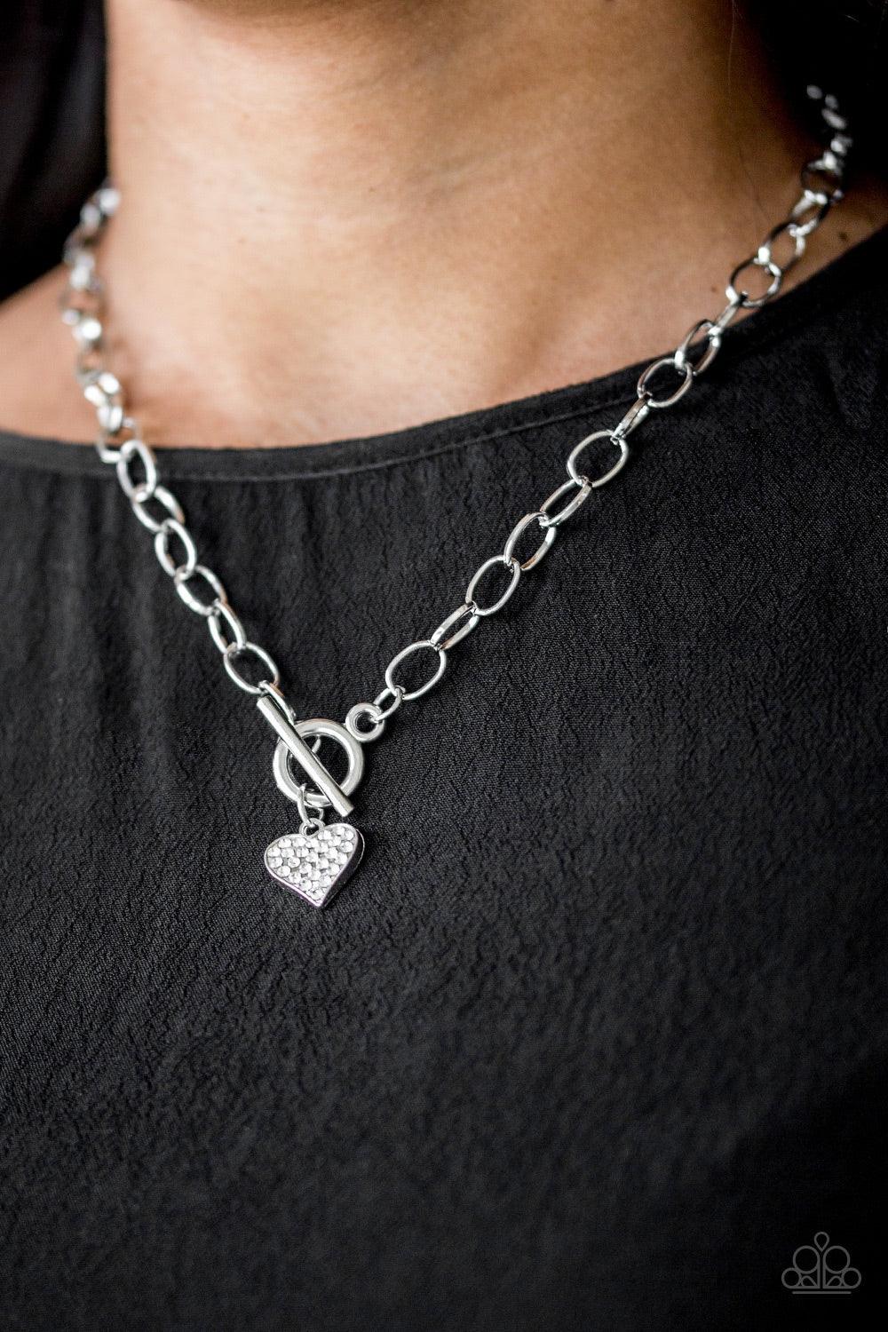 Paparazzi Accessories Harvard Hearts - White Encrusted in glassy white rhinestones, a dainty silver heart swings from the bottom of a glistening silver chain for a classic look. Features a toggle closure. Jewelry