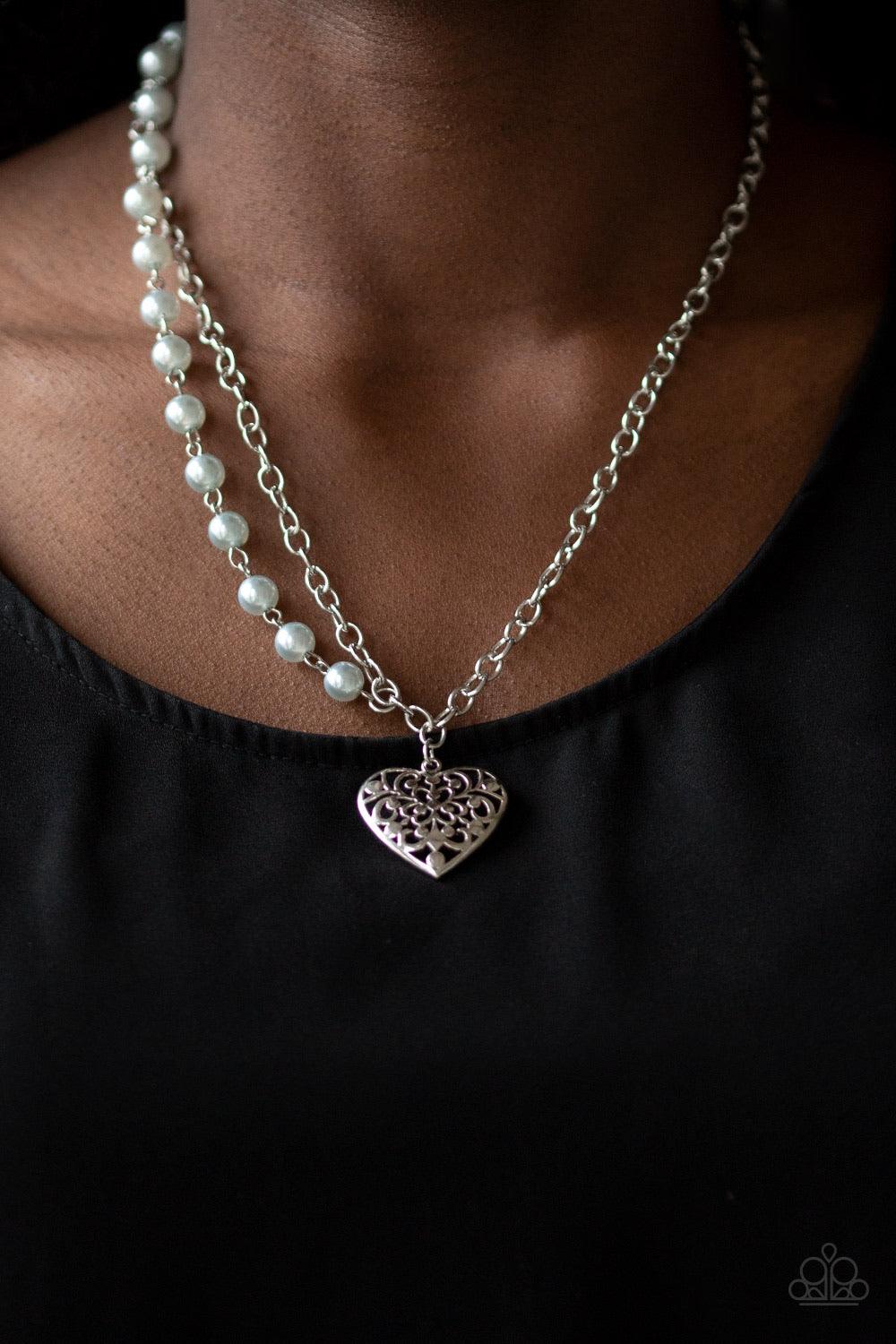 Paparazzi Accessories Forever In My Heart - Silver Swirling with filigree details, a whimsical heart pendant swings from the bottom of a shimmery silver chain below the collar. A single strand of pearly silver beads drape down one side for a refined asymm