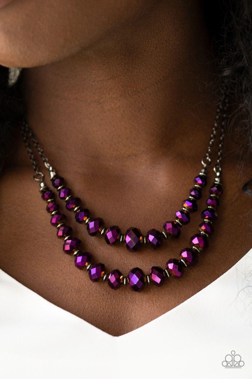 Paparazzi Accessories Strikingly Spellbinding - Purple Brushed in an iridescent shimmer, metallic purple gems are threaded along invisible wires, creating gorgeous layers beneath the collar. The glittery gems gradually increase in size near the center for