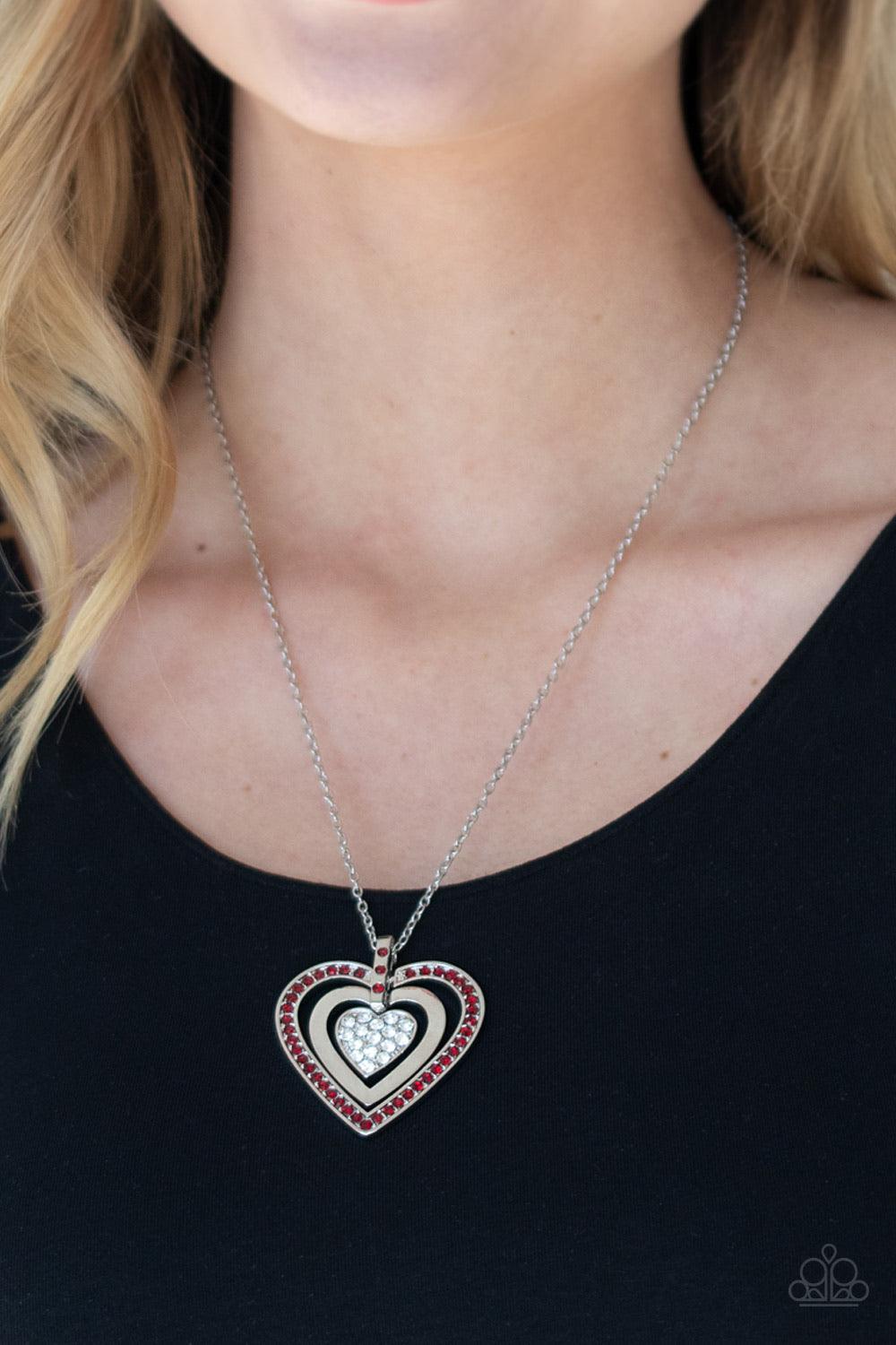 Paparazzi Accessories Bless Your Heart - Red A red rhinestone encrusted heart, shiny silver heart, and glittery white rhinestone encrusted heart swings from the bottom of a red rhinestone dotted fitting, creating a romantically oversized pendant below the