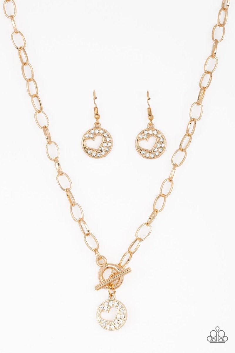 Paparazzi Accessories Heartbeat Retreat - Gold Radiating with glittery white rhinestones, an airy heart pendant swings from the bottom of a glistening gold chain below the collar for a flirty flair. Features a toggle clasp. Sold as one individual necklace