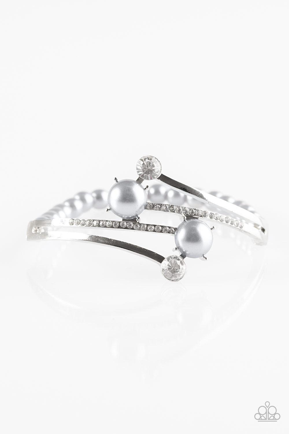 Paparazzi Accessories Can Only Go UPSCALE - Silver Encrusted in glittery white rhinestones, shimmery silver bars crisscross across the wrist. Dotted with pearly silver and sparkling white rhinestone fittings, the elegant centerpiece attaches to a stretchy