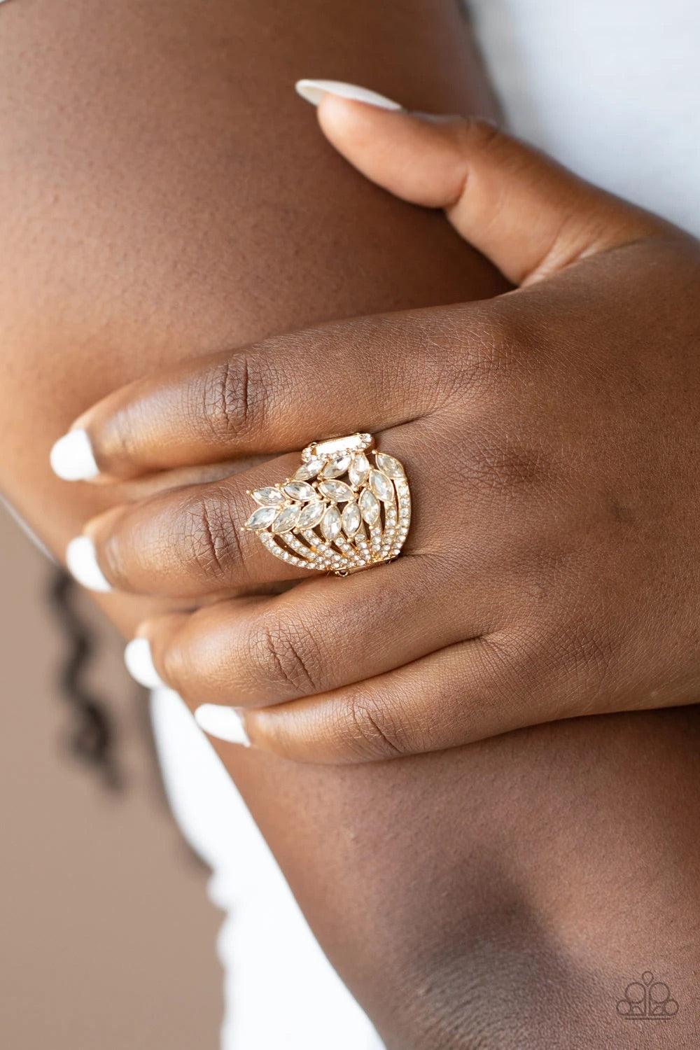 Paparazzi Accessories Clear-Cut Cascade - Gold Attached to white rhinestone encrusted gold bands, a cascade of white marquise cut rhinestones fans across the finger, coalescing into a gorgeous statement maker. Features a stretchy band for a flexible fit.