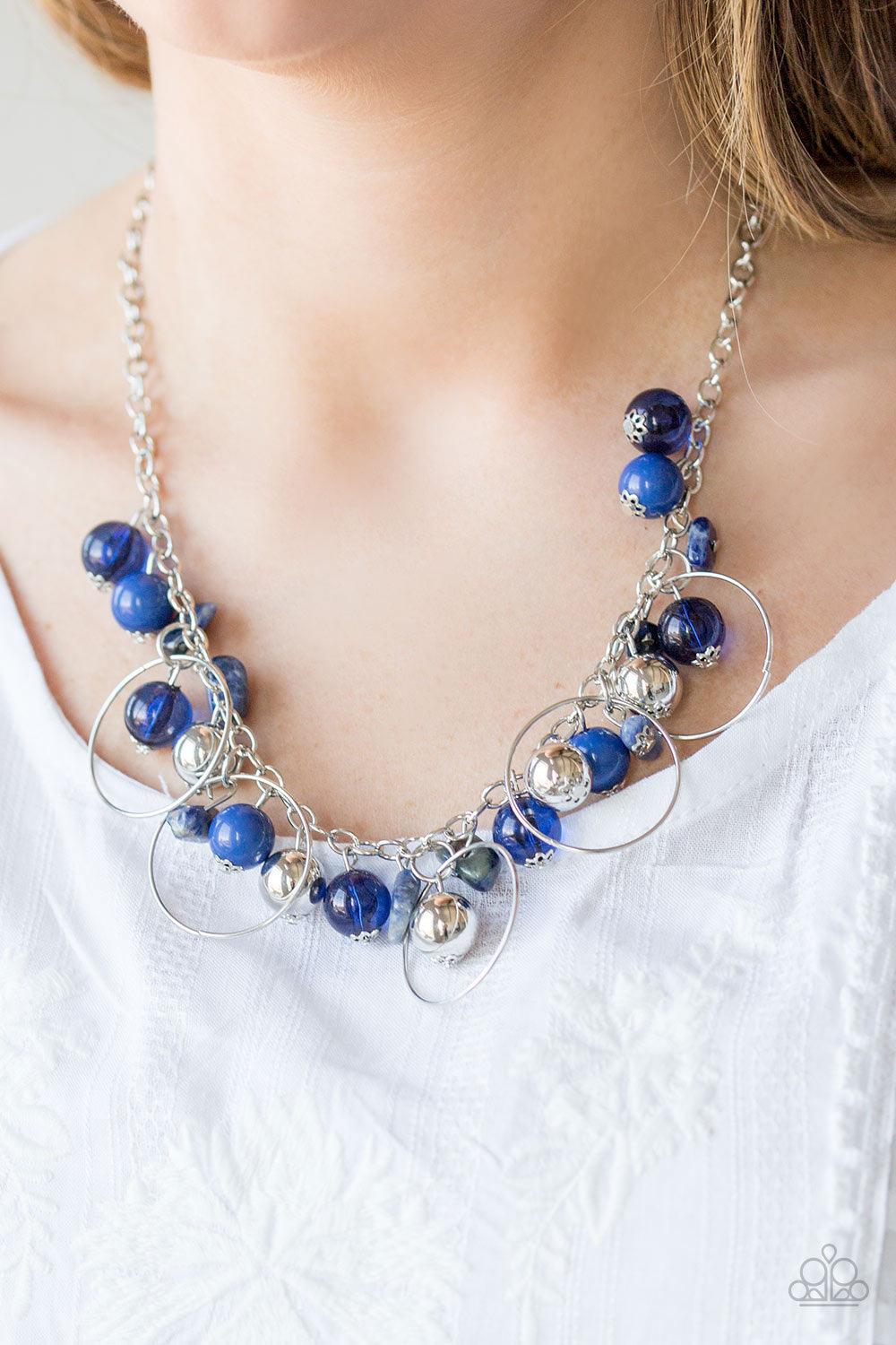 Paparazzi Accessories Mountain Mosaic - Blue Glassy blue, polished blue, and classic silver chains swing from the bottom of a shimmery silver chain. Infused with large silver hoops, bits of tranquil blue rock beading trickle between the beaded accent, cre
