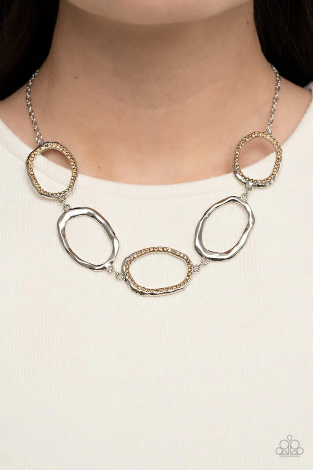 Paparazzi Accessories Gritty Go-Getter A row of dazzling light topaz rhinestones makes its way around a delicately hammered imperfect circular frame. The airy frames alternately link end to end with similar shiny silver frames creating a glitzy fashion ac