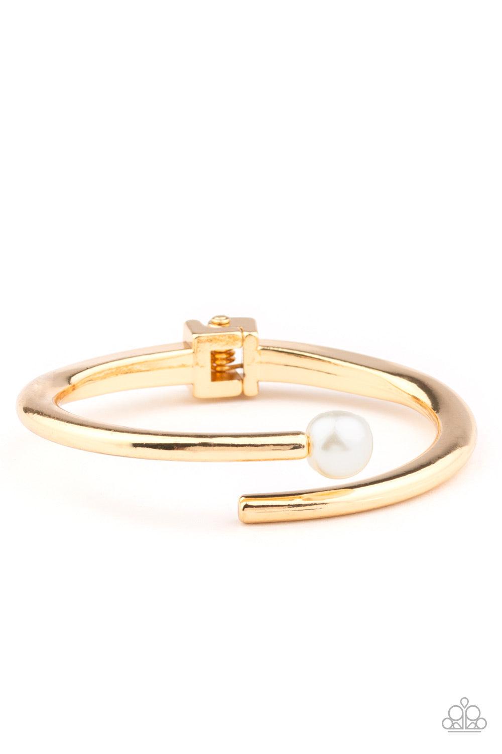 Paparazzi Accessories Industrial Impact ~Gold Featuring a solitaire white pearl, two shiny gold bars attach to a spring-like fitting as they curl around the wrist for a modern finish.