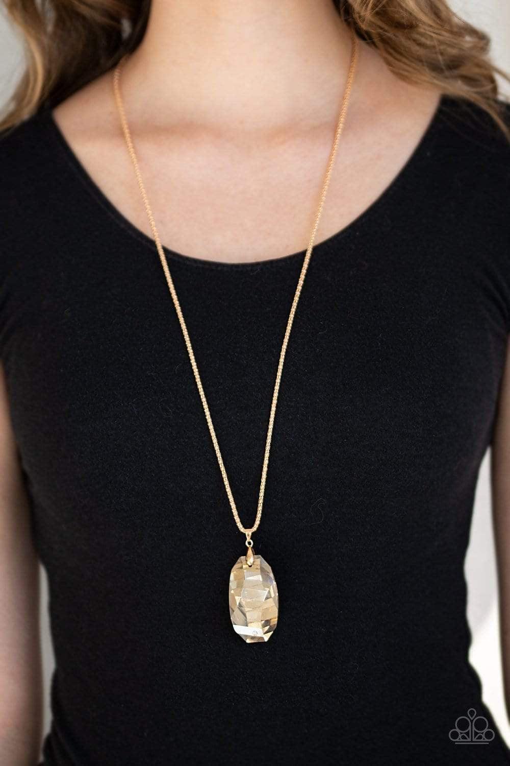 Paparazzi Accessories Gemstone Grandeur - Gold Featuring a raw cut and metallic backing, a golden gem swings from the bottom of an elongated gold popcorn chain. Dotted with a dainty white rhinestone, the faceted gem catches and refracts the light for a bl